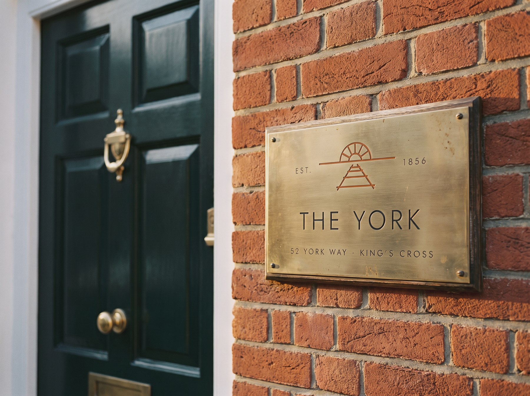 A brass room plaque on a door